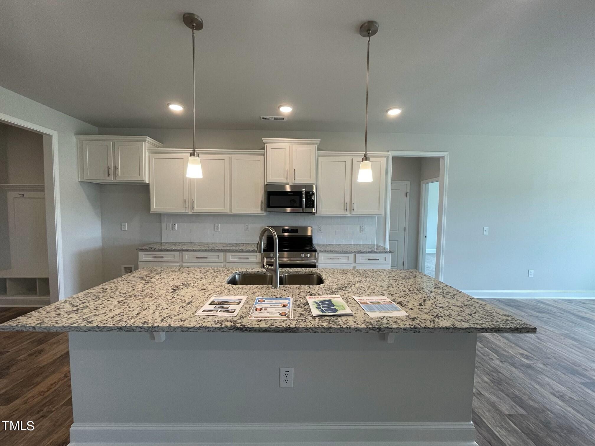 4356 Coolwater Drive Bailey, NC 27807 - Photo 4 of 17 a kitchen with kitchen island granite countertop a sink a counter top space stainless steel appliances and cabinets