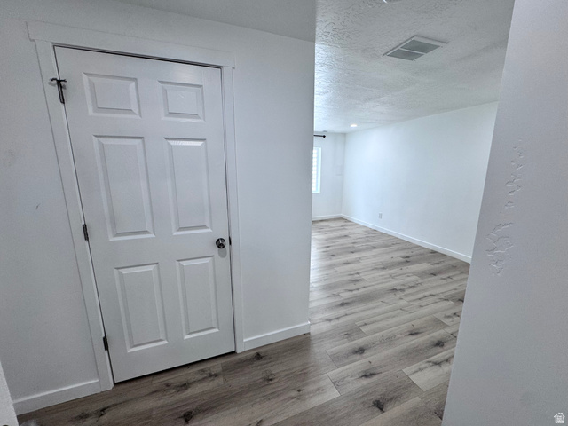 12339 Remy Road, Unit 422 Herriman, UT 84096 - Photo 31 of 36 Hall featuring light wood finished floors and a textured ceiling