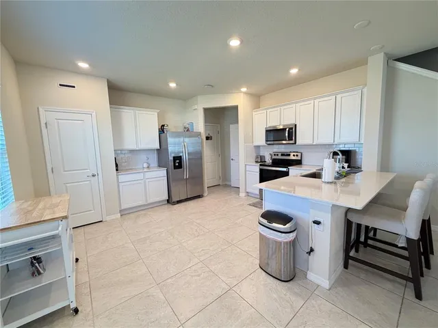 a kitchen with a refrigerator and a stove top oven
