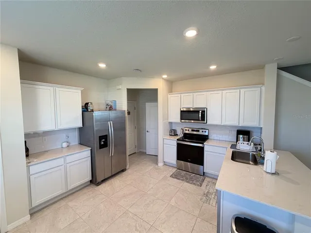 a kitchen with stainless steel appliances granite countertop a refrigerator stove microwave and sink