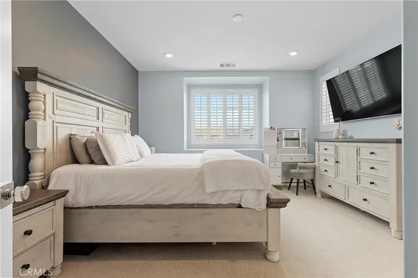 a bedroom with a bed and flat screen tv