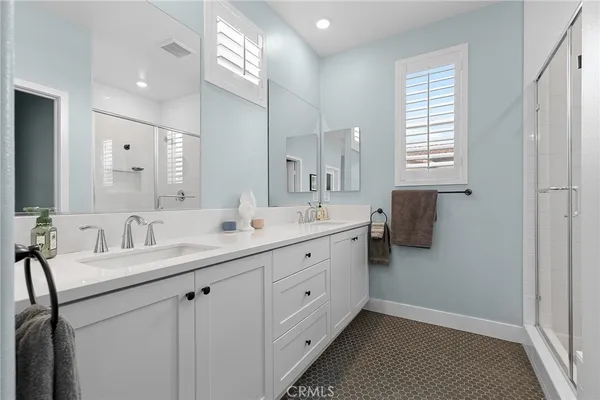 a spacious bathroom with a double vanity sink a mirror and a shower