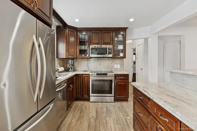 a kitchen with stainless steel appliances granite countertop a refrigerator stove and sink