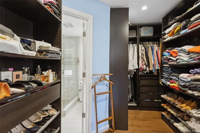 a view of walk in closet with clothes and shoes