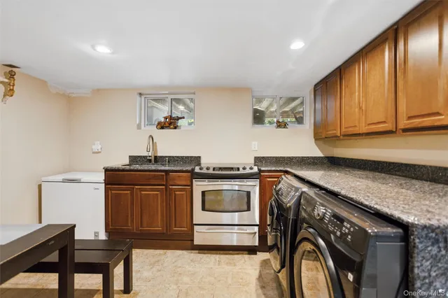 a kitchen with stainless steel appliances granite countertop a stove a sink dishwasher and cabinets with wooden floor