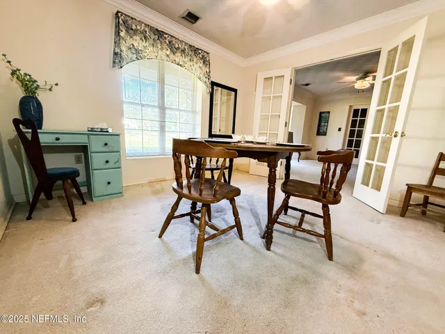 a view of a dining room with furniture and a window