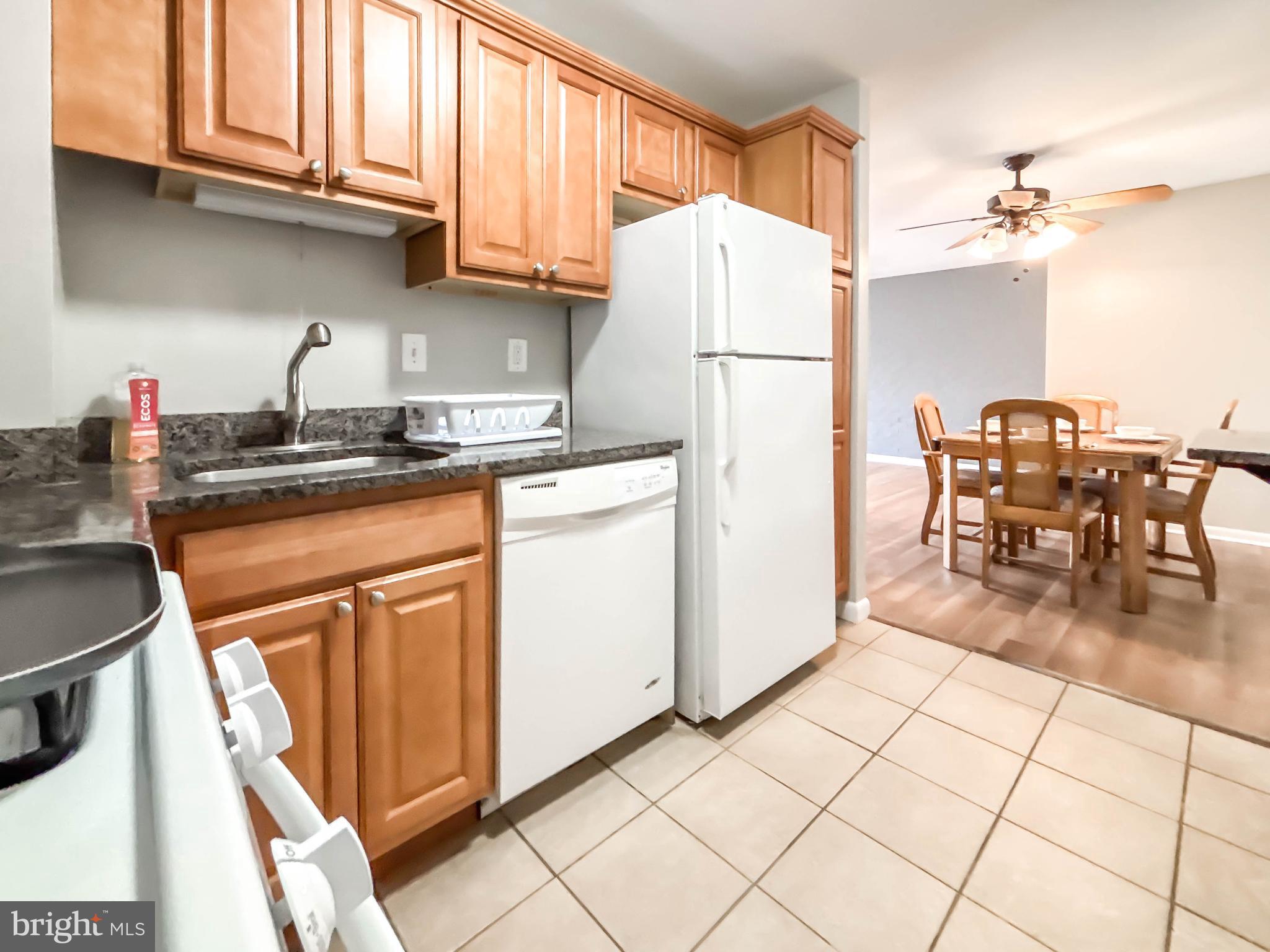 130 Slade Avenue, Unit 414 Baltimore, MD 21208 - Photo 37 of 48 a kitchen with granite countertop a refrigerator a stove a sink and a cabinets