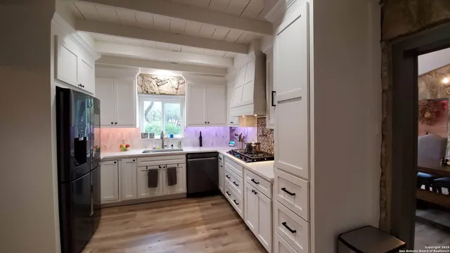 a kitchen with a stove a sink and a window