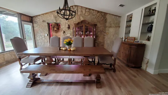a view of a hallway with wooden floor and a bathroom