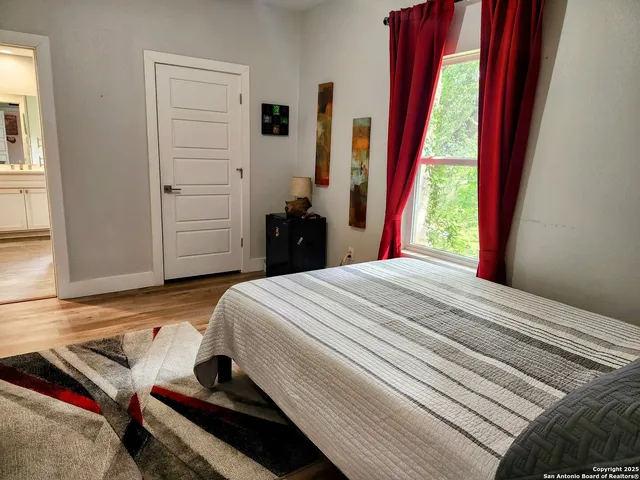 a bedroom with a bed and wooden floor