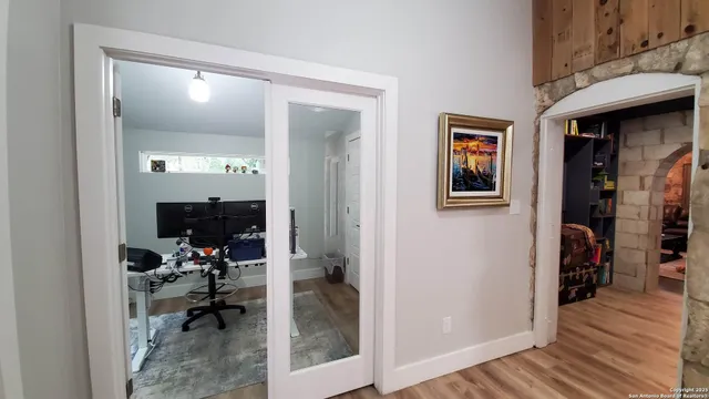 a view of a hallway with a livingroom and a hall with wooden floor