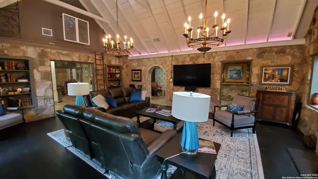 a living room with furniture a chandelier and a flat screen tv