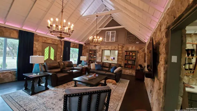 a living room with furniture a chandelier and a dining table