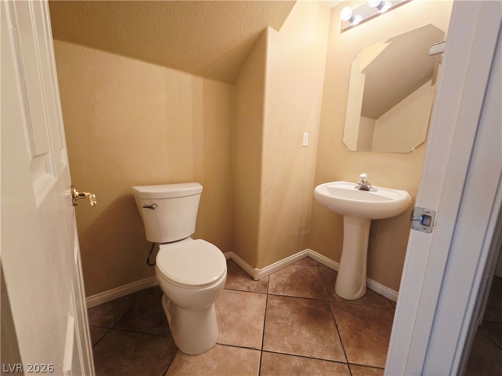 1265 Moon Vision Street Henderson, NV 89052 - Photo 17 of 35 Half bathroom with a textured ceiling and light tile patterned floors