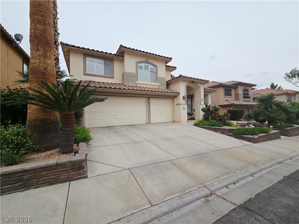 1265 Moon Vision Street Henderson, NV 89052 - Photo 2 of 35 Mediterranean / spanish house featuring stucco siding, concrete driveway, a garage, and a tile roof