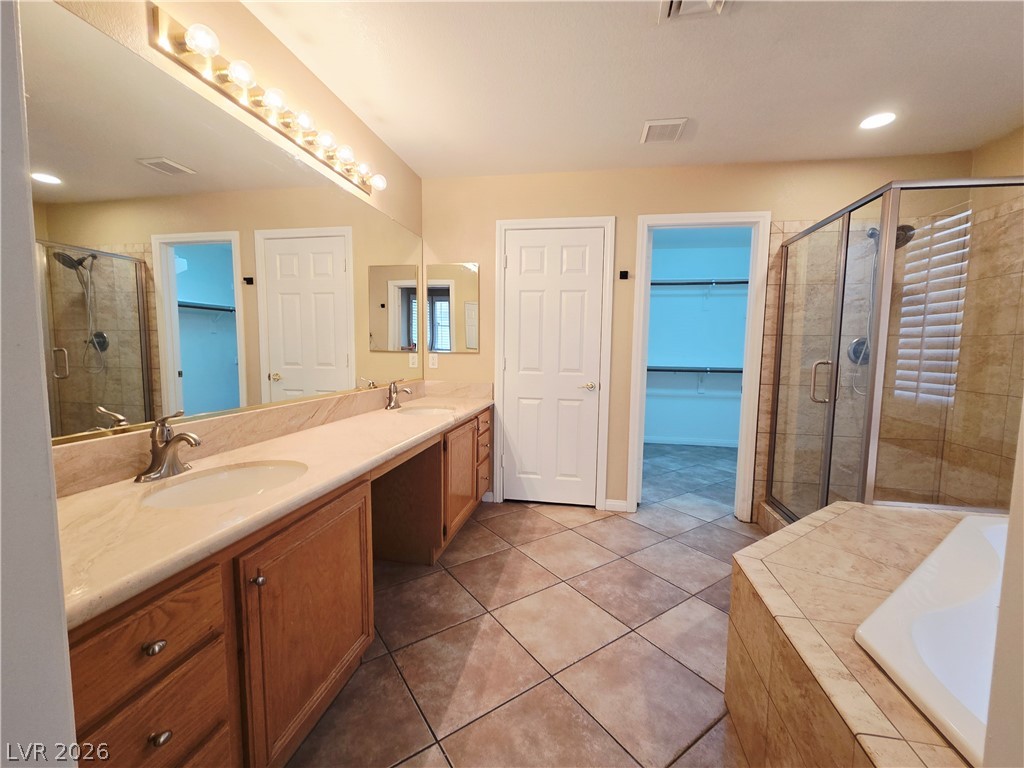 1265 Moon Vision Street Henderson, NV 89052 - Photo 21 of 35 Full bathroom featuring double vanity, a shower stall, a walk in closet, a bath, and recessed lighting