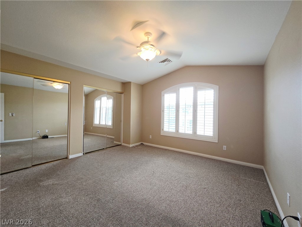 1265 Moon Vision Street Henderson, NV 89052 - Photo 31 of 35 Unfurnished bedroom with two closets, lofted ceiling, carpet flooring, and ceiling fan