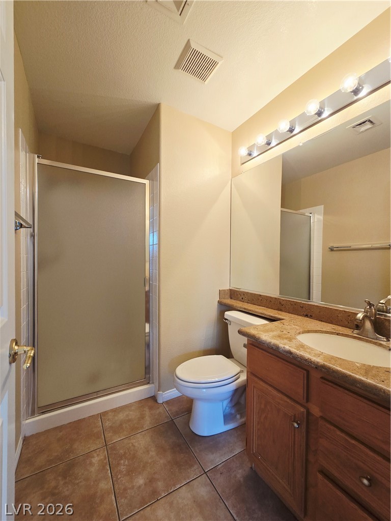 1265 Moon Vision Street Henderson, NV 89052 - Photo 32 of 35 Bathroom with vanity, a stall shower, dark tile patterned floors, and a textured ceiling
