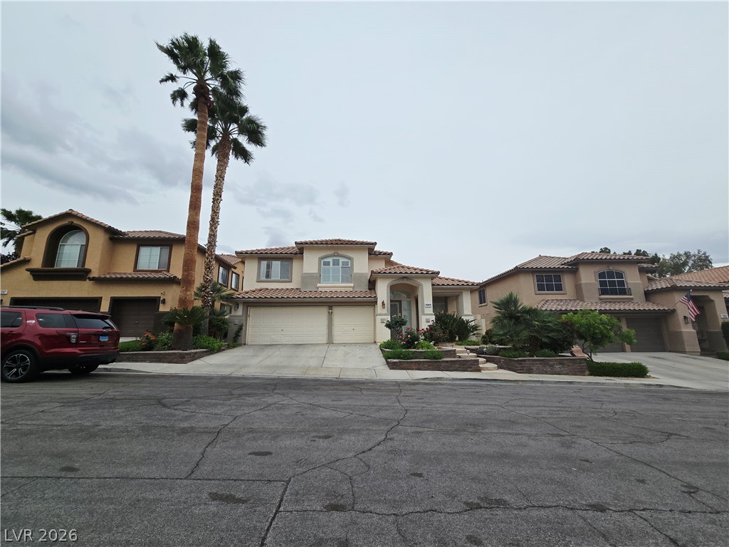 1265 Moon Vision Street Henderson, NV 89052 - Photo 34 of 35 Mediterranean / spanish-style home with stucco siding, a tile roof, a garage, and driveway