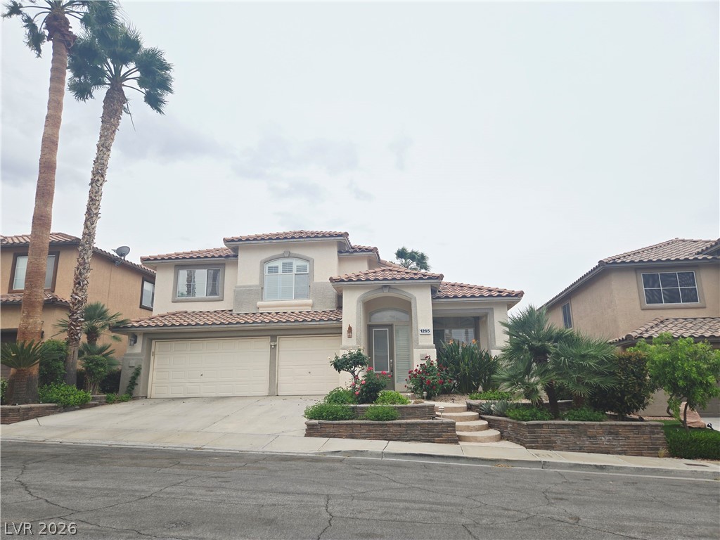 1265 Moon Vision Street Henderson, NV 89052 - Photo 35 of 35 Mediterranean / spanish-style house with stucco siding, a tile roof, concrete driveway, and a garage