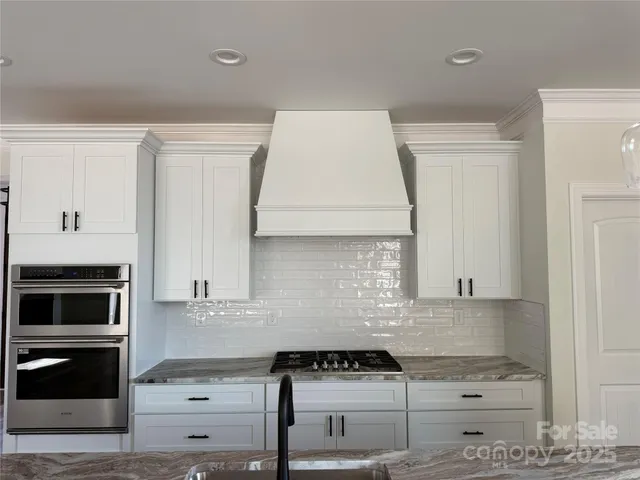 a kitchen with granite countertop a stove and a microwave