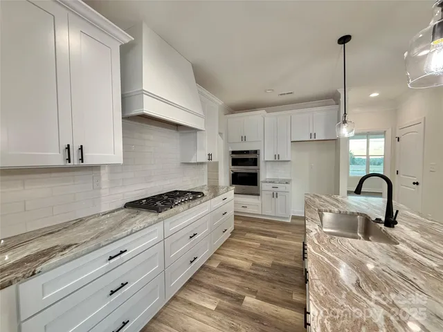 a kitchen with granite countertop a stove and a sink