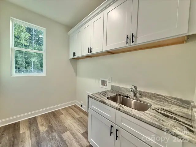 a view of an empty room with window and chandelier