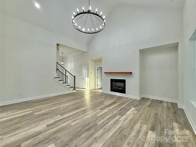 a view of empty room with wooden floor and fireplace
