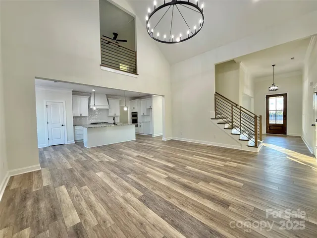 a view of empty room with a kitchen and wooden floor