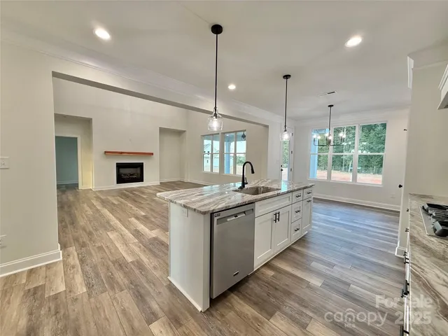 a kitchen with stainless steel appliances granite countertop a stove and a wooden floors