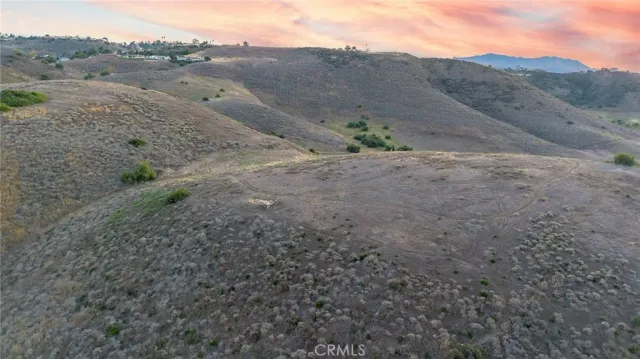 a view of a dry field with mountains in the background