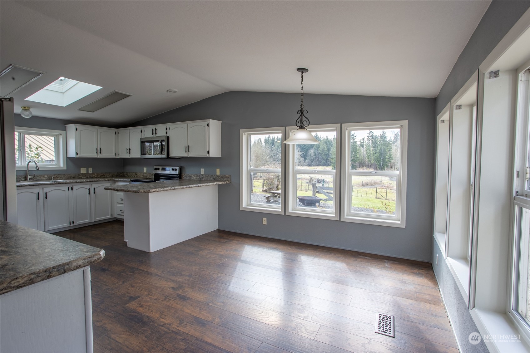 219 Lindbeck Road Winlock, WA 98596 - Photo 5 of 35 a kitchen with stainless steel appliances granite countertop a stove top oven a sink with a dining table and chairs