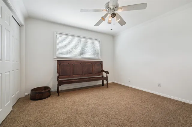 an empty room with windows and ceiling fan