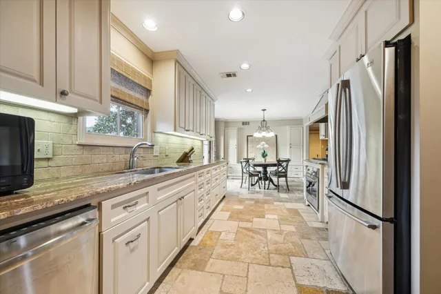 a kitchen with stainless steel appliances granite countertop a refrigerator and a sink