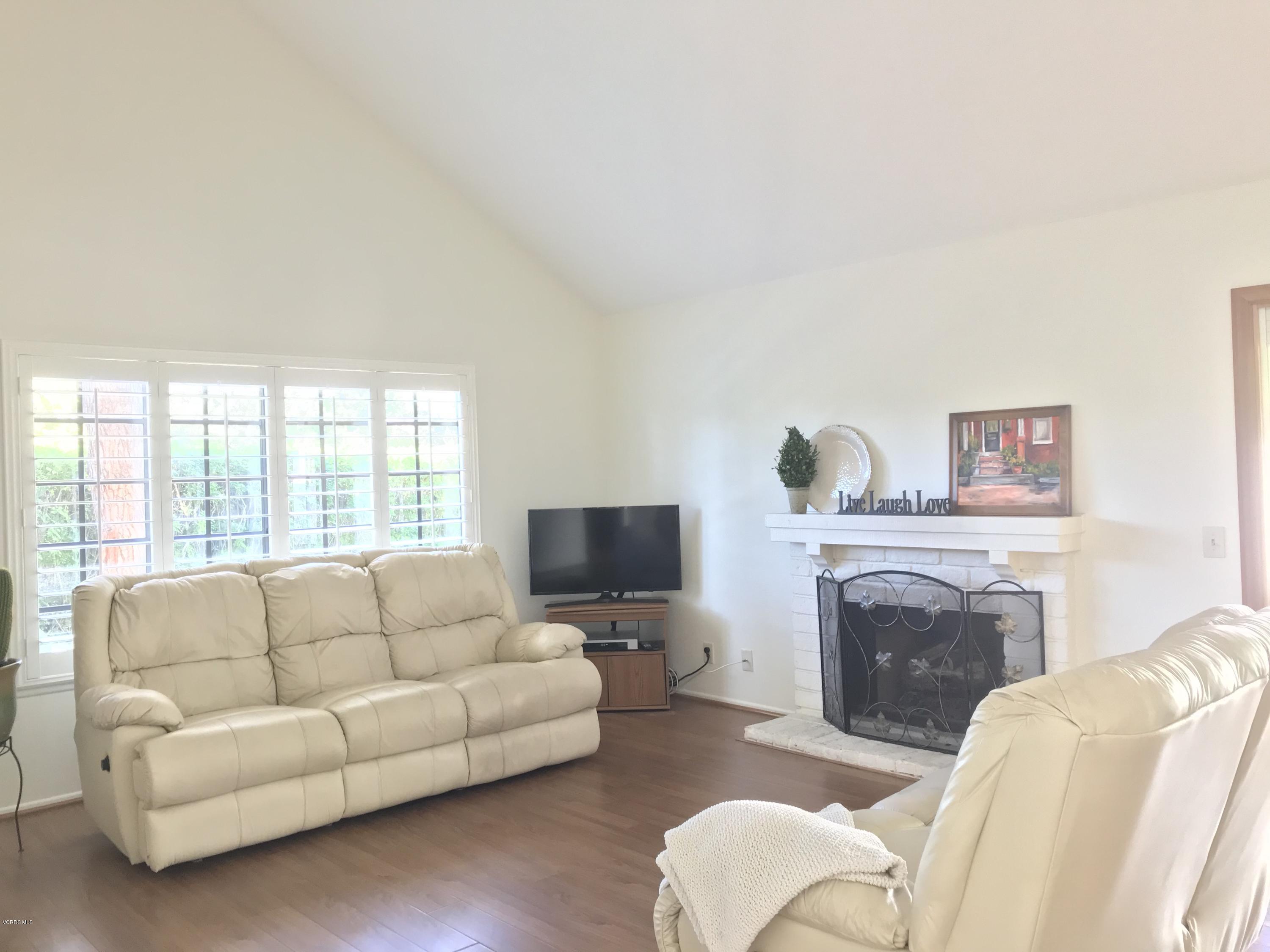 971 Thistlegate Road Oak Park, CA 91377 - Photo 2 of 33 a living room with furniture a flat screen tv and a fireplace
