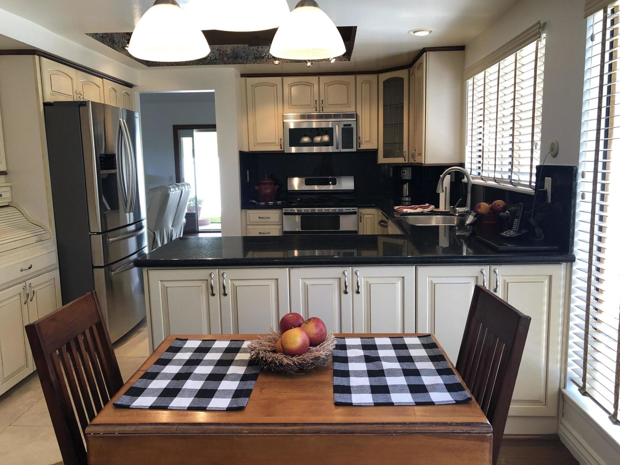 971 Thistlegate Road Oak Park, CA 91377 - Photo 11 of 33 a kitchen with stainless steel appliances a dining table and chairs