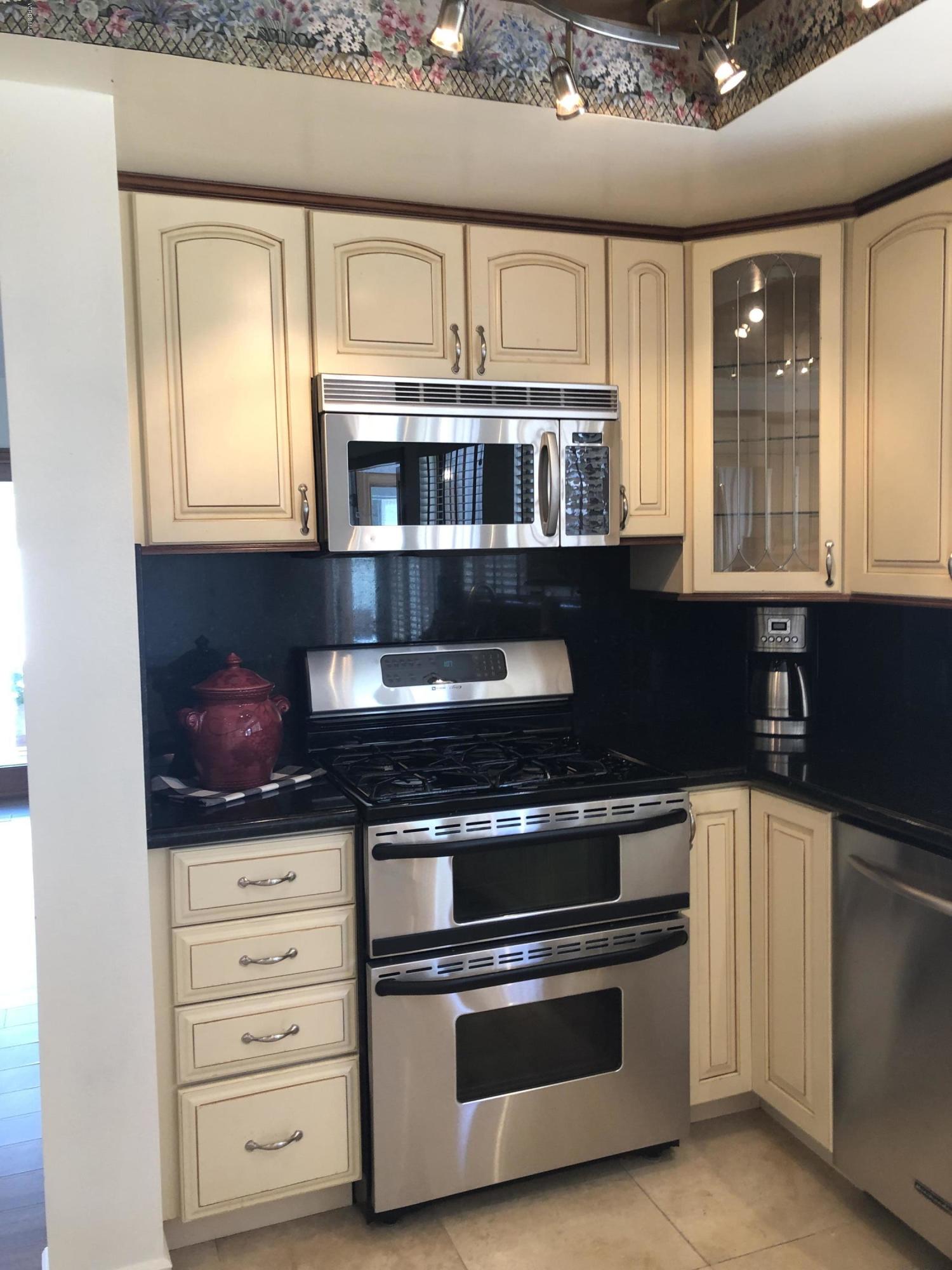 971 Thistlegate Road Oak Park, CA 91377 - Photo 13 of 33 a kitchen with stainless steel appliances granite countertop a stove and a microwave