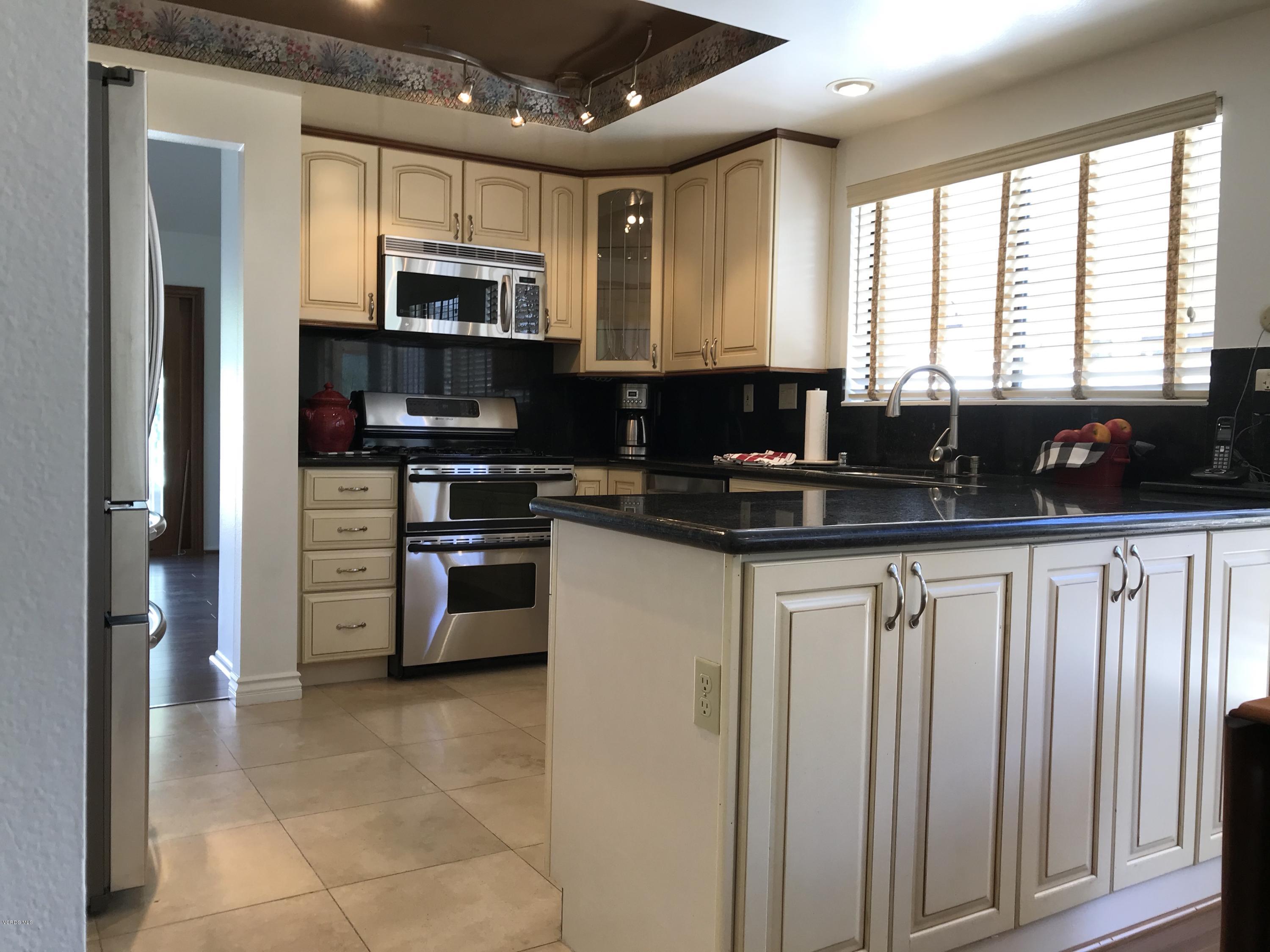 971 Thistlegate Road Oak Park, CA 91377 - Photo 17 of 33 a kitchen with stainless steel appliances a stove sink microwave and cabinets