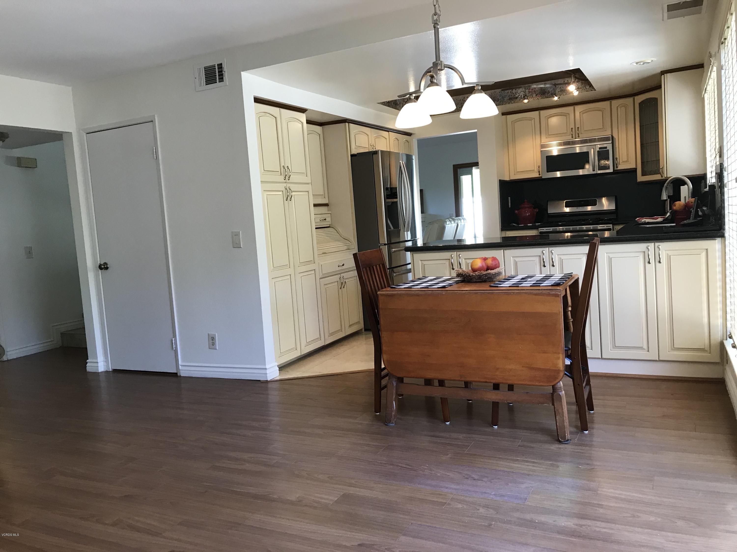 971 Thistlegate Road Oak Park, CA 91377 - Photo 18 of 33 a living room with furniture a flat screen tv and kitchen view