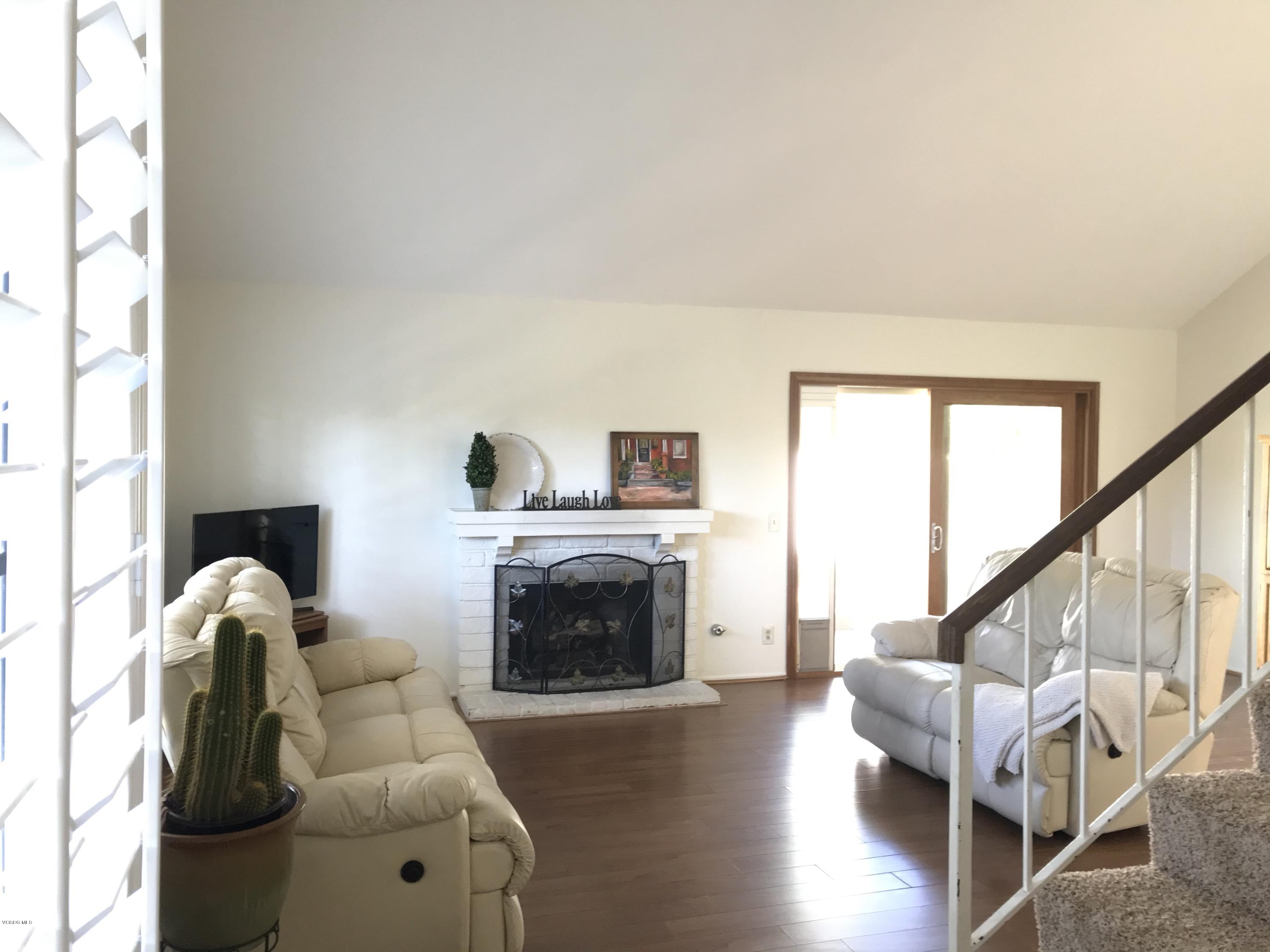 971 Thistlegate Road Oak Park, CA 91377 - Photo 3 of 33 a living room with furniture a fireplace and a floor to ceiling window