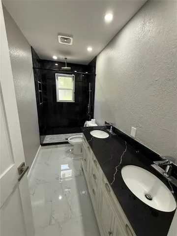 a bathroom with a sink and mirror with toilet