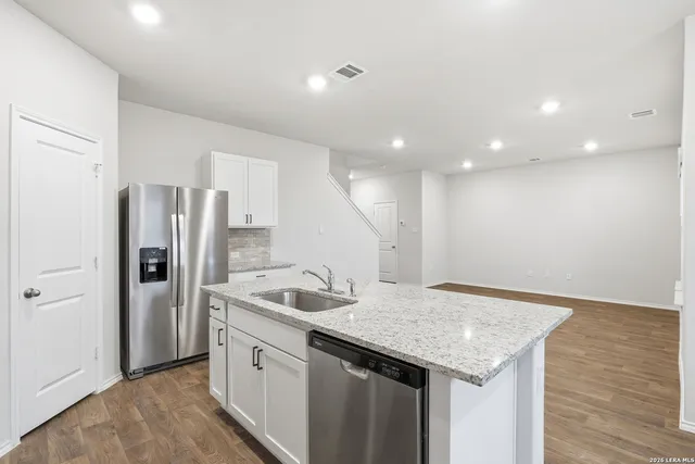 a kitchen with stainless steel appliances granite countertop a sink and refrigerator