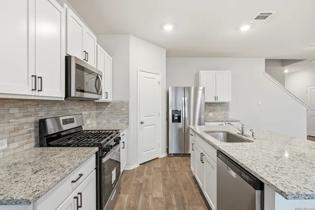 a kitchen with stainless steel appliances granite countertop a sink stove microwave and cabinets