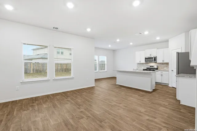 a view of kitchen with granite countertop cabinets and refrigerator