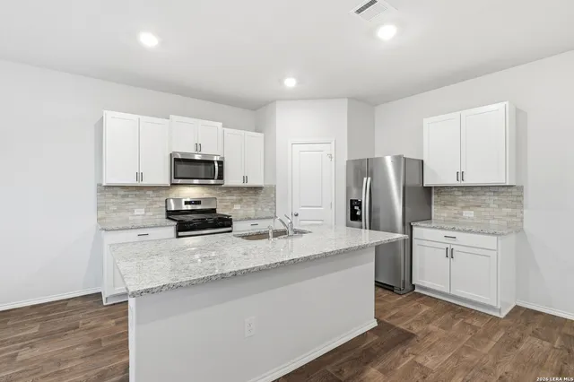 a kitchen with stainless steel appliances granite countertop a refrigerator stove microwave and sink