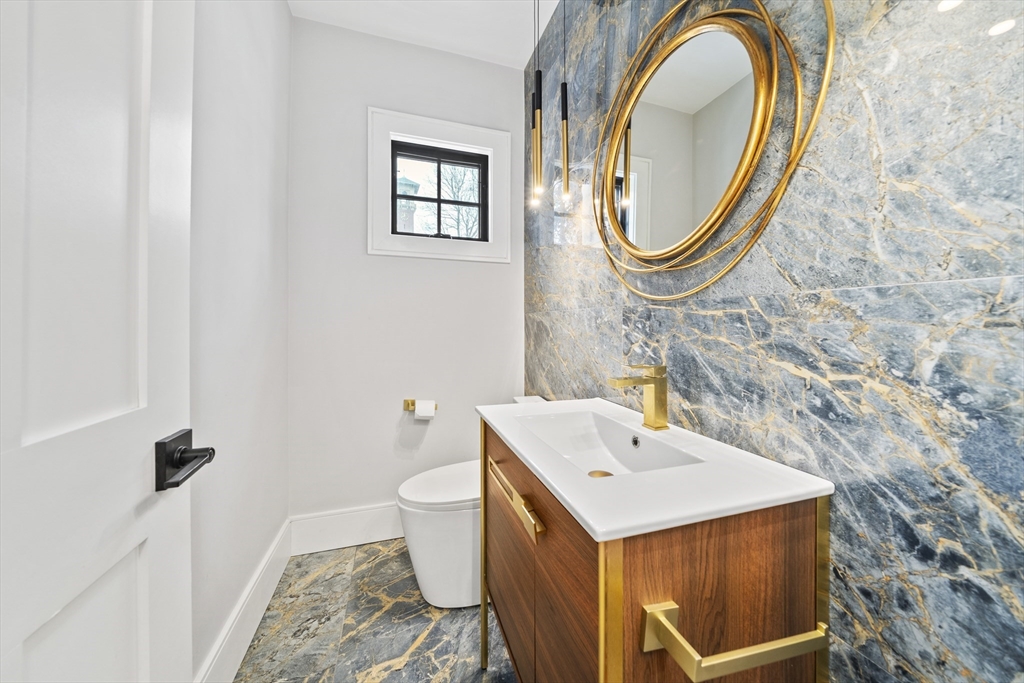 300 Elliot Street, Unit 2 Newton, MA 02464 - Photo 12 of 42 a bathroom with a sink a mirror and a toilet