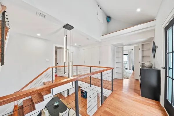 a view of a hallway with wooden floor and workspace