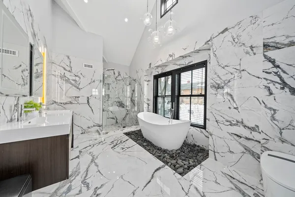 a bathroom with a double vanity sink toilet mirror and bathtub
