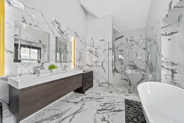 a white bath tub sitting in a bathroom next to a window