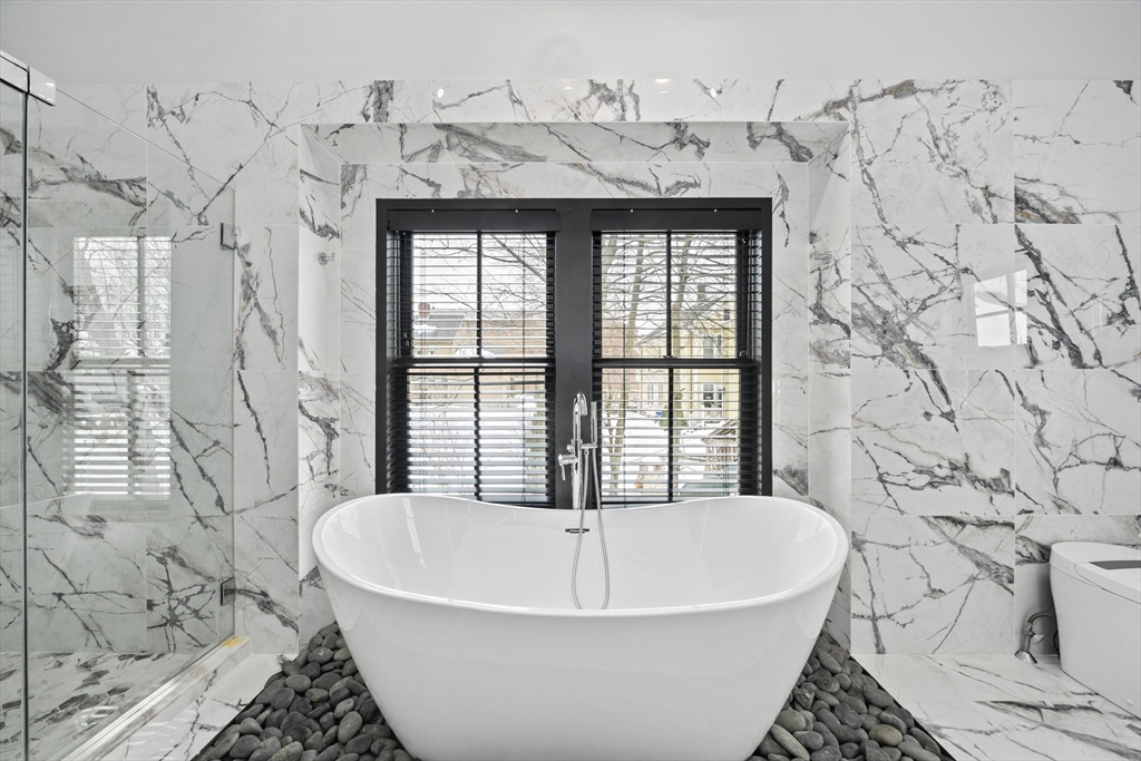 300 Elliot Street, Unit 2 Newton, MA 02464 - Photo 23 of 42 a white bath tub sitting in a bathroom next to a window